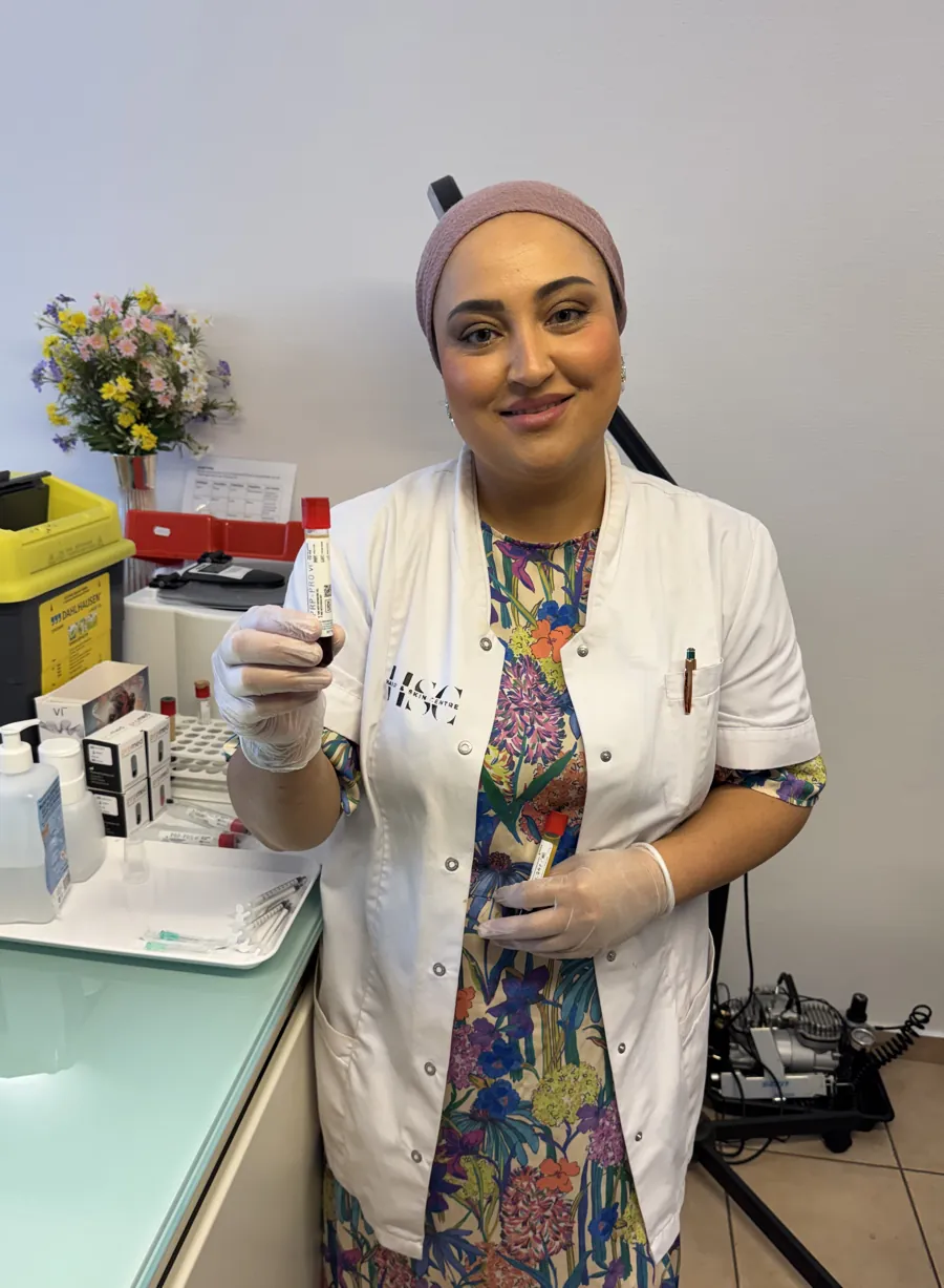 Elaha Wahidi in witte schort aan de werktafel van Hair & Skin Centre Gent